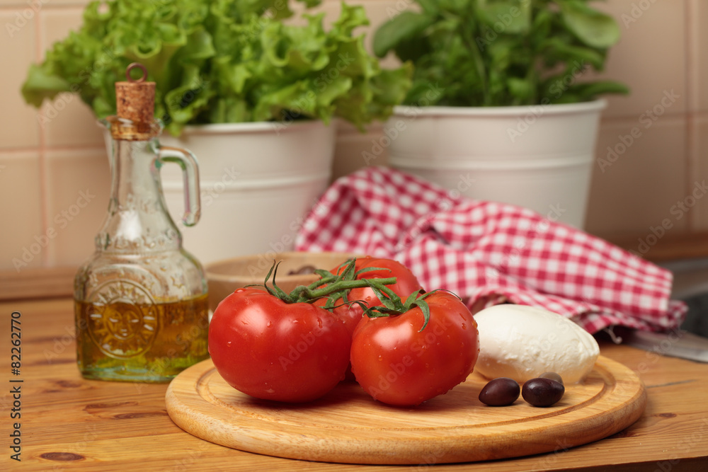 Tomatoes and mozzarella on a kitchen table Tomatoes and mozzarella on a kitchen table