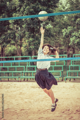 Cute Thai schoolgirl is playing beach volleyball in school