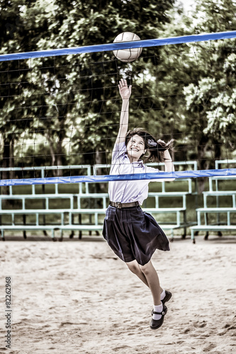 Cute Thai schoolgirl is playing beach volleyball in school unifo photo