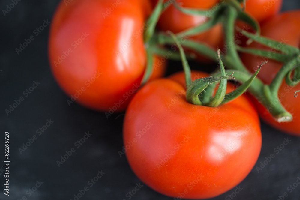 Tasty and fresh tomatoes on a black stone serving board Tasty and fresh tomatoes on a black stone serving board