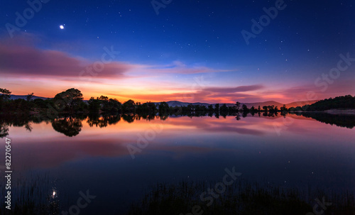 Beautiful spring night on the pond  with stars, clouds and refle photo