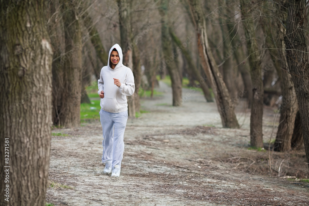 Fototapeta premium Cheerful young man jogging in nature