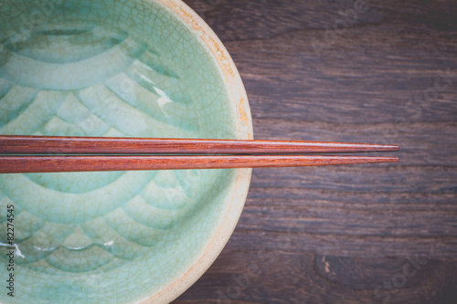 Canvastavla chopsticks and celadon green ceramic on wood table background