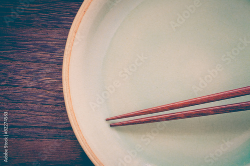  chopsticks and celadon green ceramic on wood table background