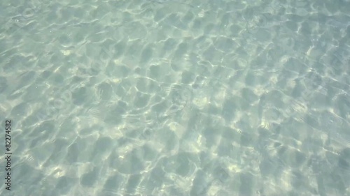 Rippling surface of clear shallow water with sandy bottom