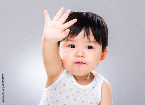 Young baby greeting with hand