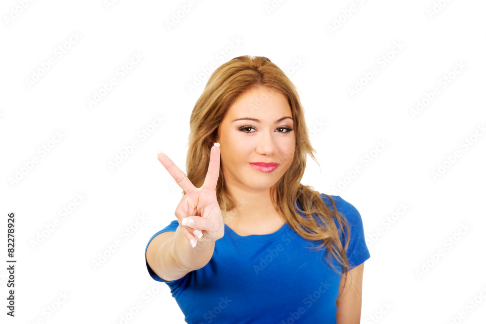 Young woman showing victory sign. Young woman showing victory sign.