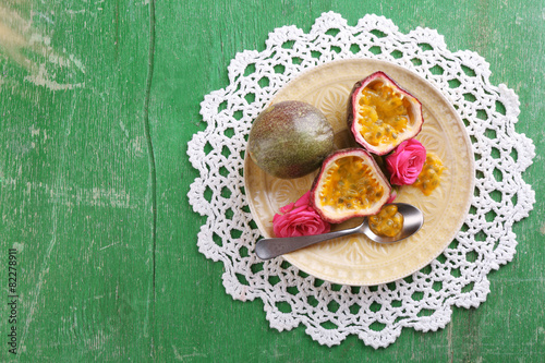 Passion fruit on plate on color wooden background