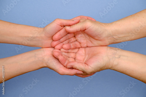 Old woman and young woman holding hands together