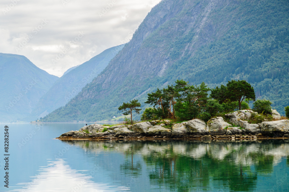 Small island with mountains background at norwegian fjord