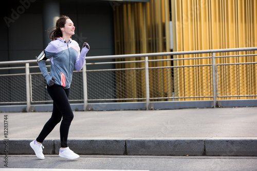 Young attractive woman running downtown