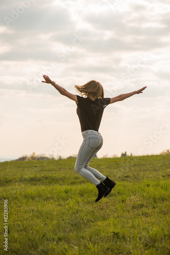 Happy Young Woman Jumping over blue sky © Laszlo