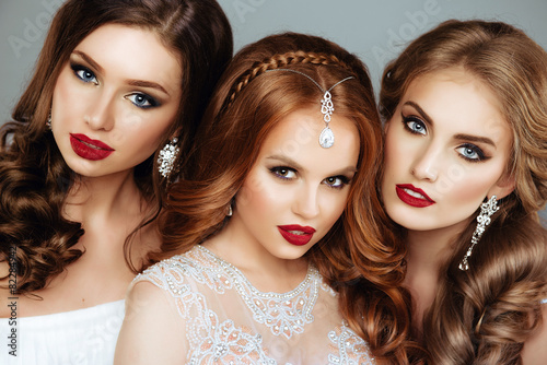 Portrait of three Beautiful Women with Fashion Make-Up and Hair