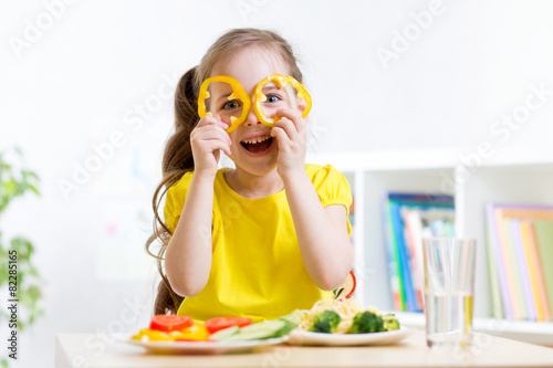 smiling child eating in kin...