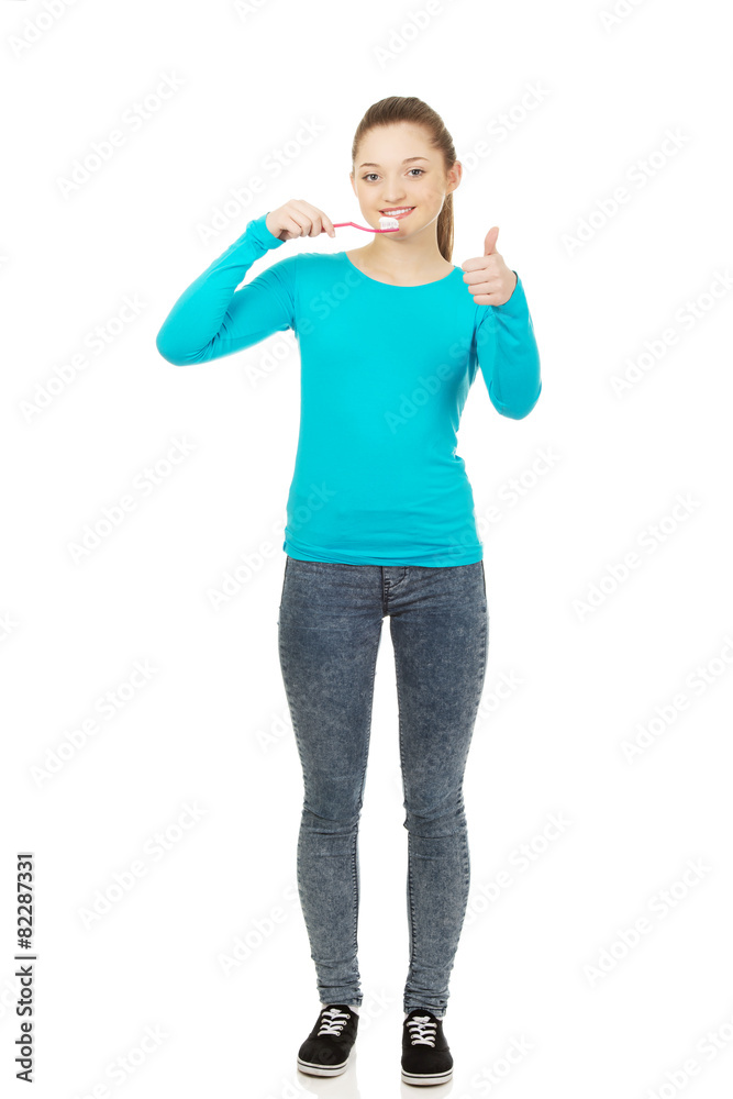Fototapeta premium Young woman brushing teeth.