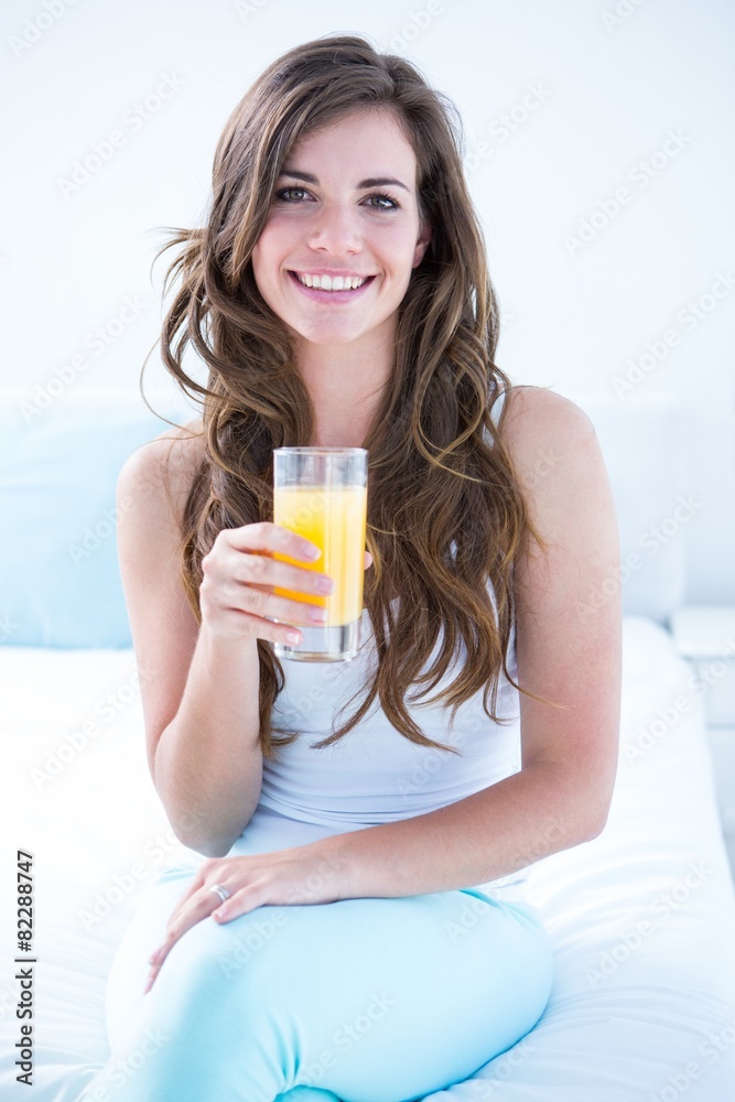 Happy woman drinking at glass of orange juice Happy woman drinking at glass of orange juice