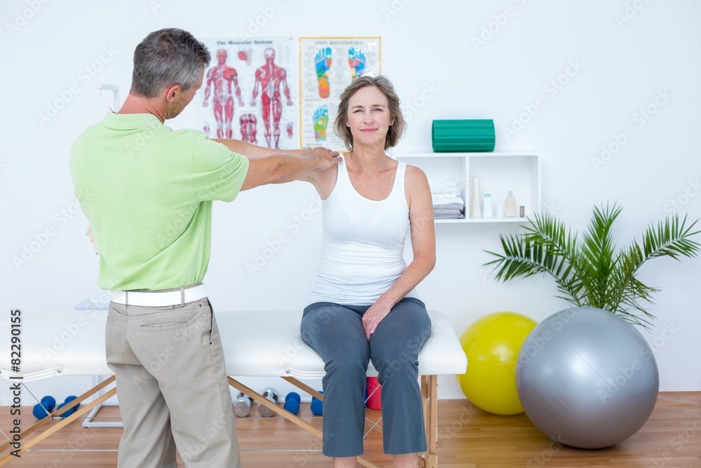 Doctor stretching his patients arm Doctor stretching his patients arm