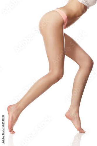 naked female legs and pink panties on a white background