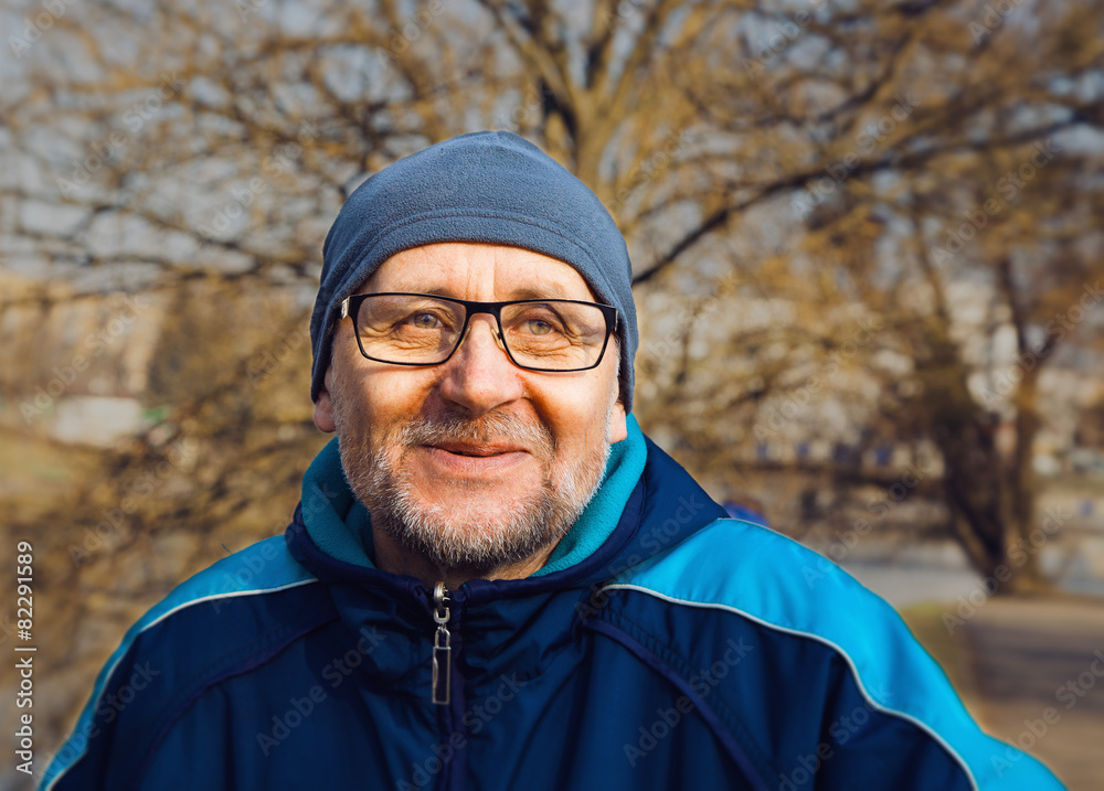 portrait of a smiling elderly man wearing glasses, a gray hat an portrait of a smiling elderly man wearing glasses, a gray hat an
