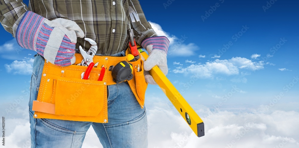 Composite image of handyman holding spirit level Composite image of handyman holding spirit level