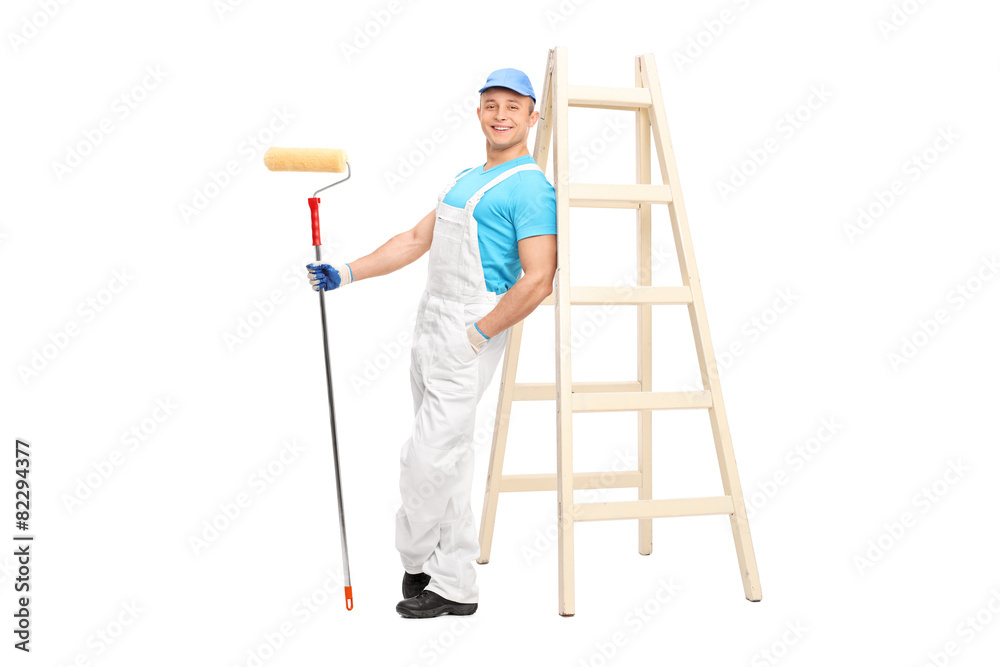 Young male decorator holding a paint roller Young male decorator holding a paint roller