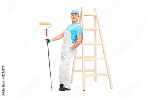 Young male decorator holding a paint roller