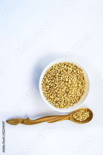 whole wheat in bowl and wooden spoon, vertical