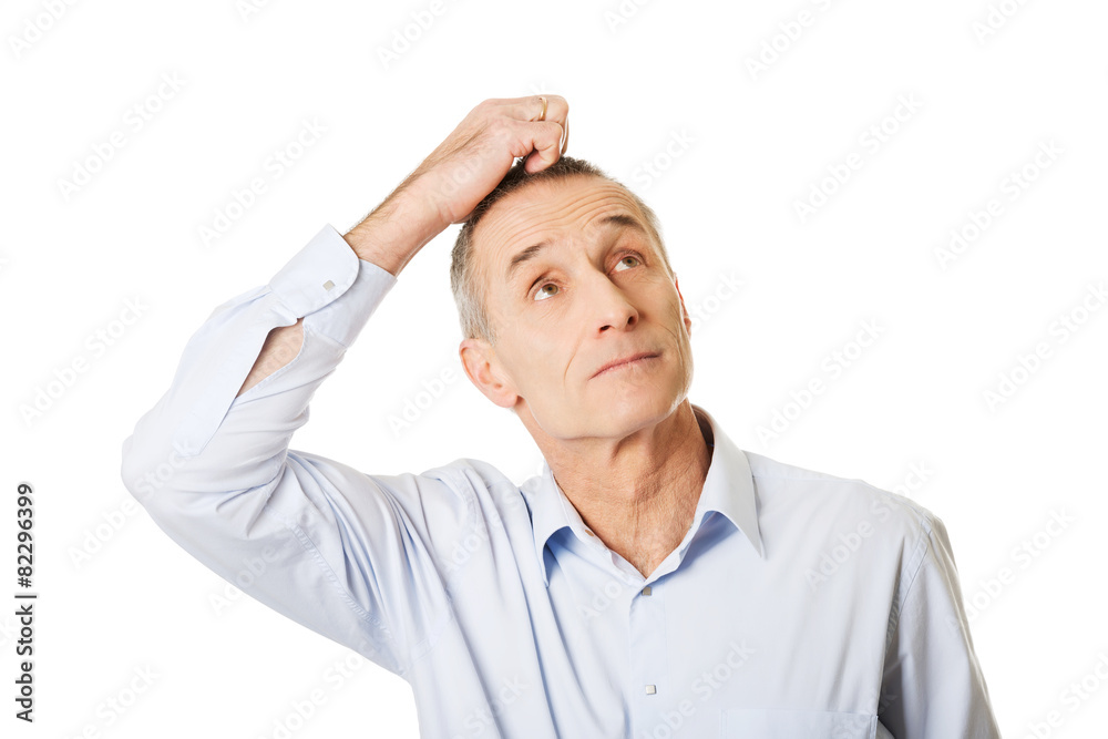 Portrait of confused man scratching his head Portrait of confused man scratching his head
