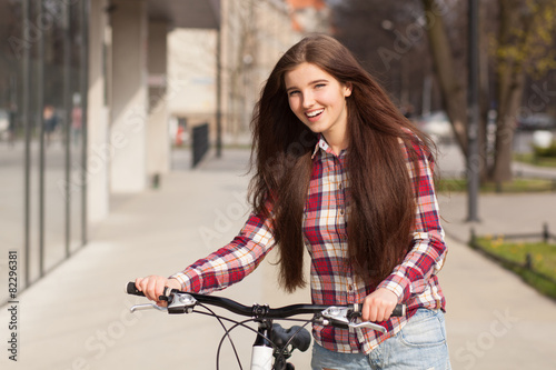 Young beautiful woman on a bicycle © George Dolgikh