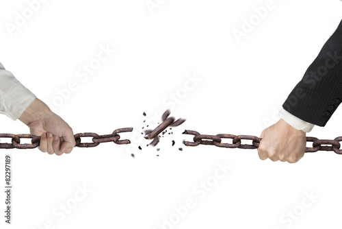 Businessman pulling rusty iron chains broken isolated on white