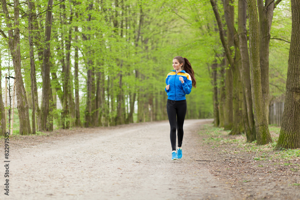 Fototapeta premium Young beautiful woman running on a trail