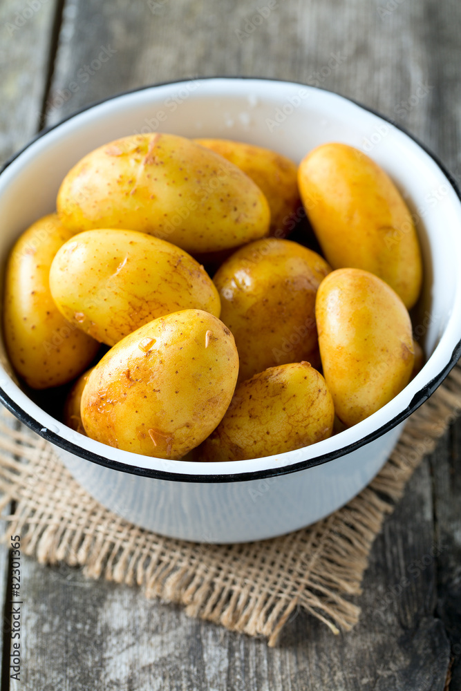 raw baby potatoes on wooden surface raw baby potatoes on wooden surface