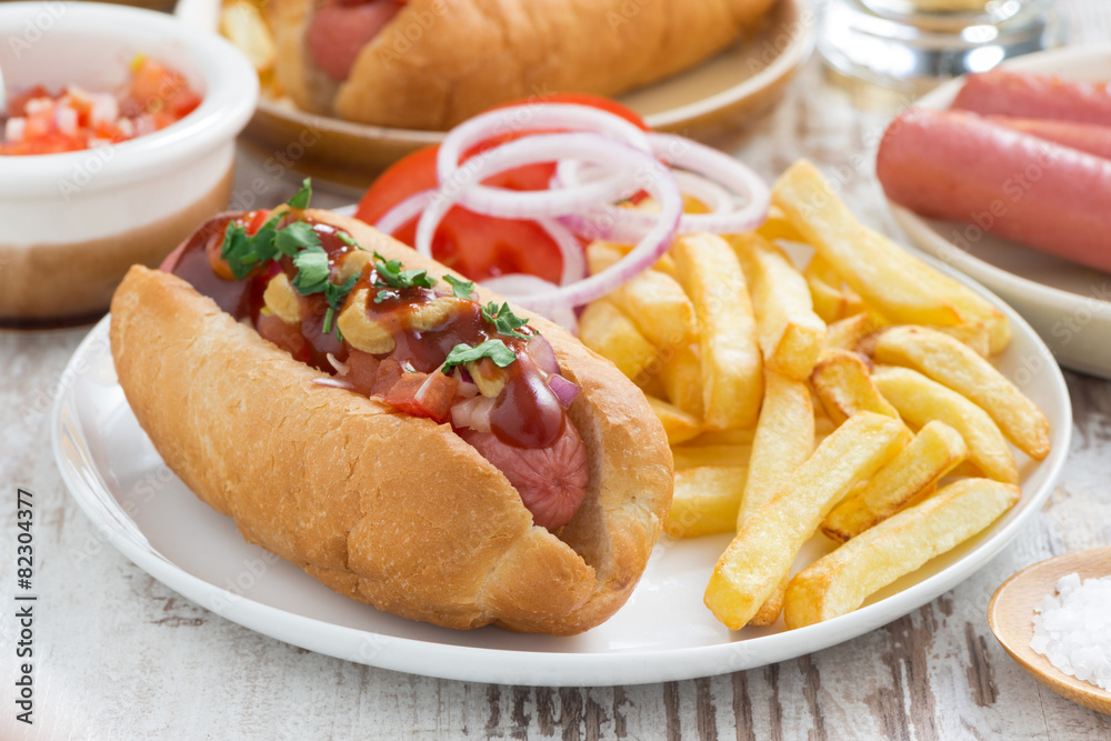 hot dogs with tomatoes, onions and french fries, close-up hot dogs with tomatoes, onions and french fries, close-up