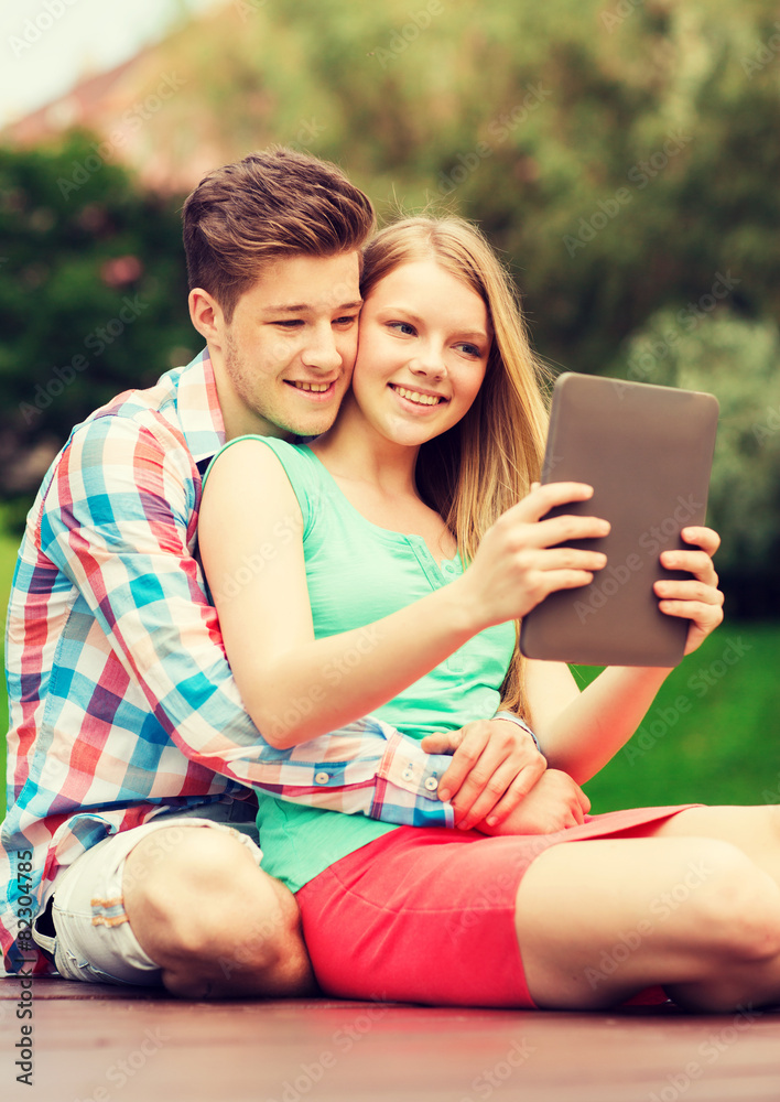 smiling couple with tablet pc making selfie