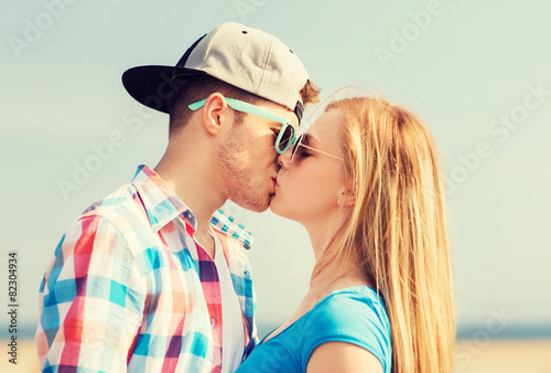 teenage couple kissing outdoors
