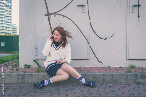 Beautiful girl talking on phone in an urban context