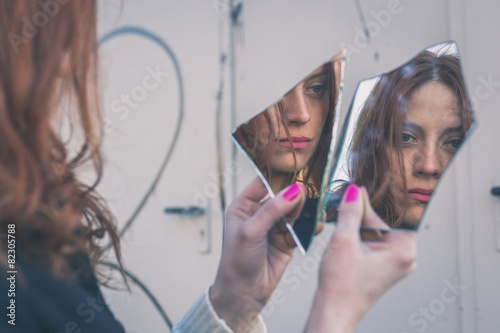 Beautiful girl looking at herself in a mirror