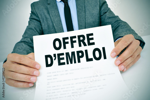 man with a document with the text offres d'emploi, jobs in frenc photo