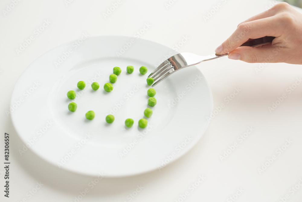 close up of woman with fork eating peas close up of woman with fork eating peas