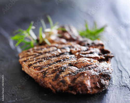 grilled prime rib beef steak with rosemary on slate