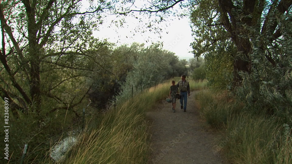 father and son walking down a trail father and son walking down a trail