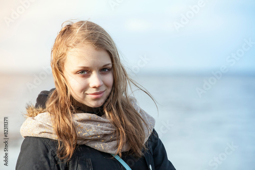 Closeup outdoor portrait of smiling beautiful blond Caucasian te © evannovostro