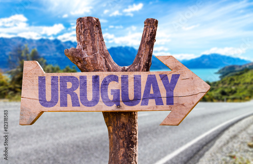 Uruguay wooden sign with road background photo