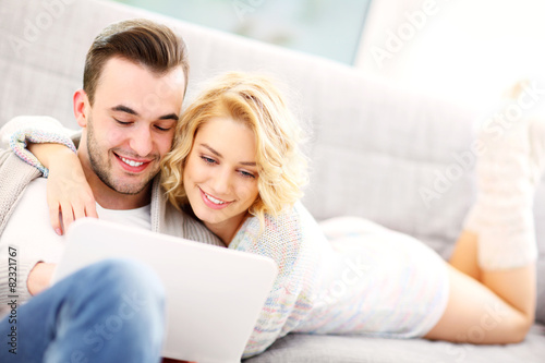 Romantic couple with laptop in living room