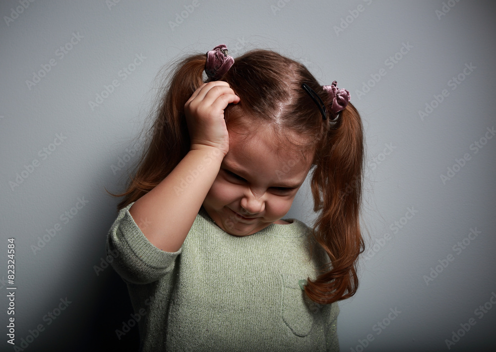Fototapeta premium Stressed kid girl with headache holding hand the head