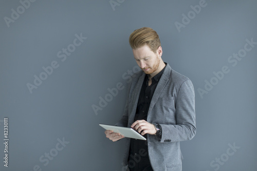 Man with tablet by the wall