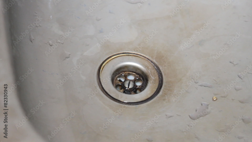 stream of water flowing down the drain in the sink stream of water flowing down the drain in the sink
