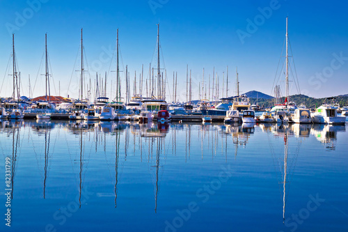 Sailboats and yachts in harbor reflections view