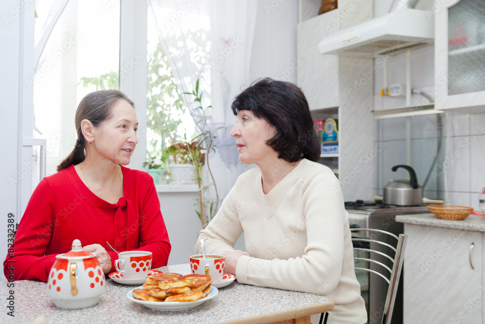 mature women talking at kitchen mature women talking at kitchen