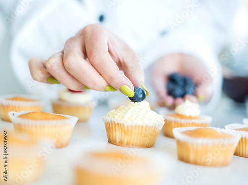 Chef hands decorating cupcakes